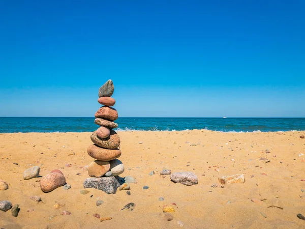 Pedras no suporte da pirâmide na praia arenosa — Fotografia de Stock