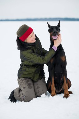 Eğitim ve Dobermans köpeklerle karlı bir sahada oynamak