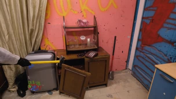 Зрілий чоловік знищує старий холодильник на санях у руїнах — стокове відео