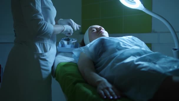Молодая женщина во время процедуры в клинике — стоковое видео