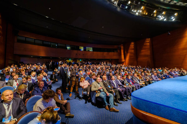 Люди принимают участие в бизнес-конференции в конгресс-зале
