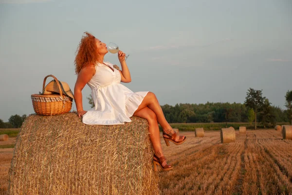 Zrzavý žena pózuje na poli nedaleko stoh sena — Stock fotografie