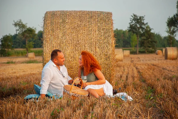 Romantic date on a freshly cut field near a haystack — Stock Photo, Image