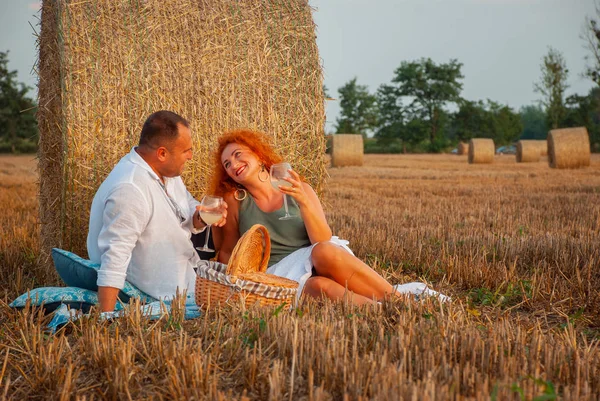 Romantische datum op een vers gesneden veld in de buurt van een hooiberg — Stockfoto