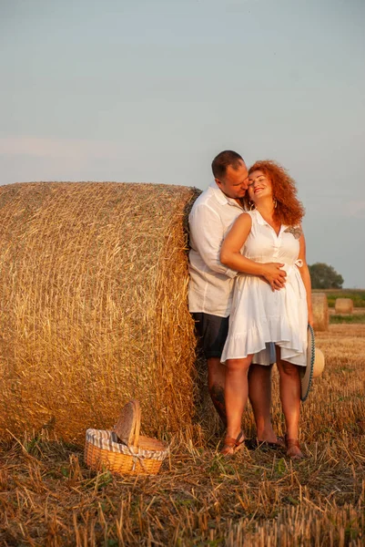 Romantische datum op een vers gesneden veld in de buurt van een hooiberg — Stockfoto