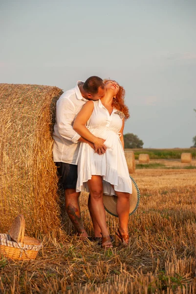 Romantische datum op een vers gesneden veld in de buurt van een hooiberg — Stockfoto