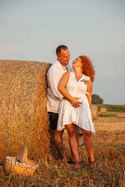 Romantische datum op een vers gesneden veld in de buurt van een hooiberg — Stockfoto