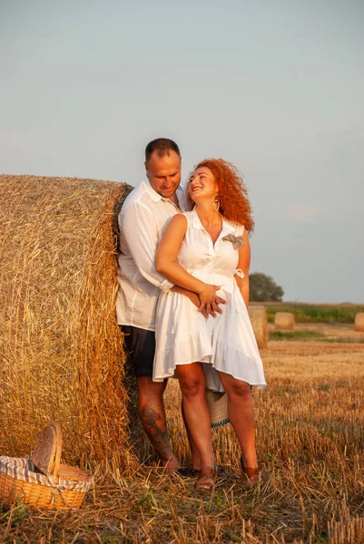 Romantische datum op een vers gesneden veld in de buurt van een hooiberg — Stockfoto