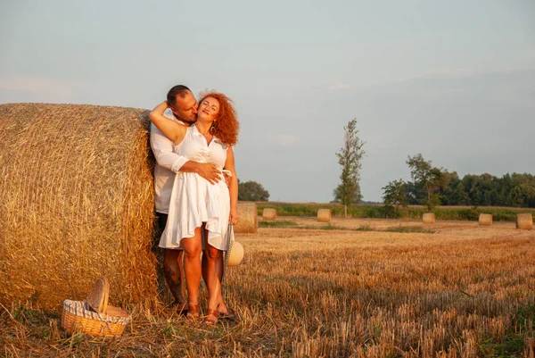 Romantische datum op een vers gesneden veld in de buurt van een hooiberg — Stockfoto