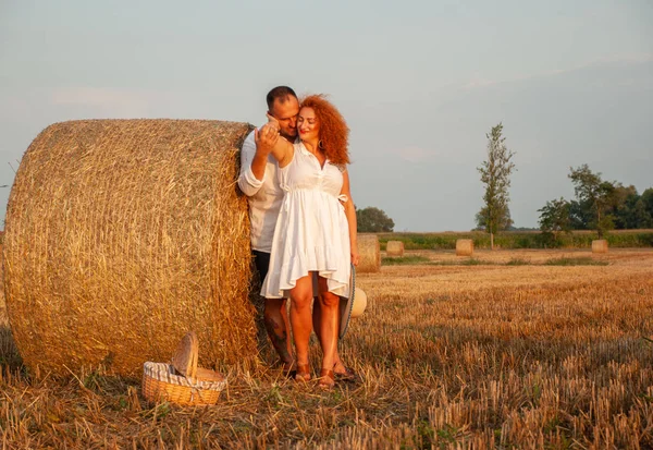 Romantische datum op een vers gesneden veld in de buurt van een hooiberg — Stockfoto