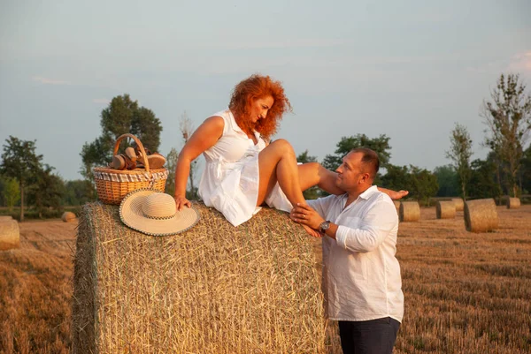 Romantische datum op een vers gesneden veld in de buurt van een hooiberg — Stockfoto