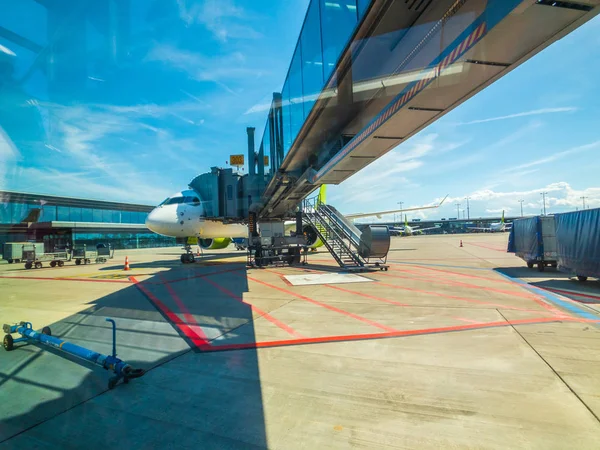Посадка на самолет Airbaltic Airlines в аэропорту в дневное время — стоковое фото