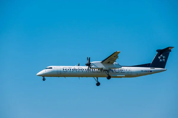 Aerolíneas de Star Alliance Bomardier Dash 8 Q400 preparándose para aterrizar en el aeropuerto internacional — Foto de Stock