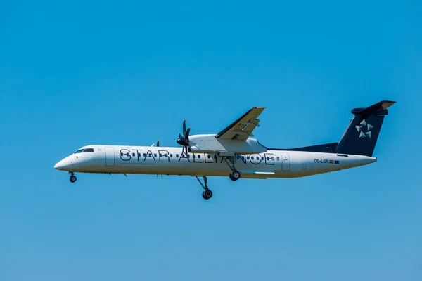 Aerolíneas de Star Alliance Bomardier Dash 8 Q400 preparándose para aterrizar en el aeropuerto internacional — Foto de Stock