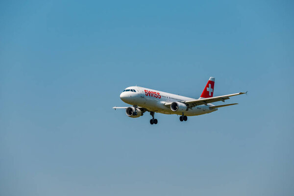 Самолеты швейцарских авиалиний готовятся к посадке в дневное время в международном аэропорту
