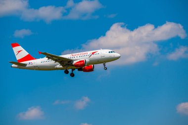 Avusturya Havayolları uçak, gündüz Zürih Uluslararası Havaalanı için iniş hazırlama mavi gökyüzünde uçan