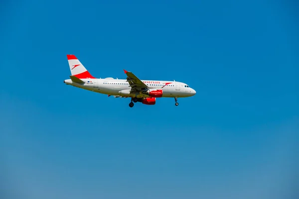 Flugzeug der Austrian Airlines fliegt am blauen Himmel und bereitet sich auf die Landung am Tag auf dem Flughafen Zürich vor — Stockfoto