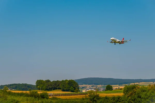 Helvetic Swiss airlines αεροπλάνο προετοιμασία για προσγείωση στο χρόνο ημέρας στο Διεθνές Αεροδρόμιο — Φωτογραφία Αρχείου