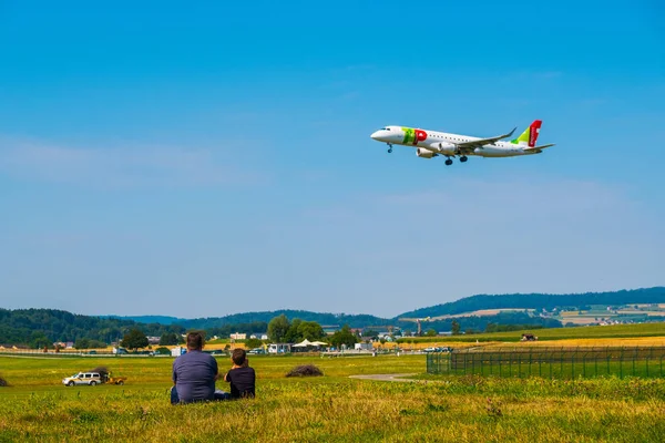 Vater und Sohn beobachten bei sonnigem Wetter die Landung von Flugzeugen am Flughafen Zürich — Stockfoto