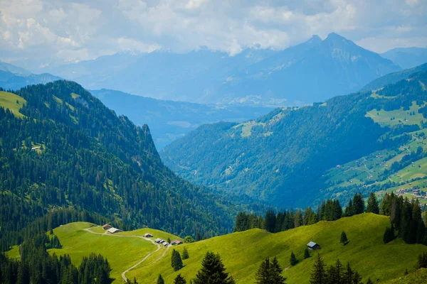 Paisaje de verano de verdes colinas un pueblo de montaña — Foto de Stock