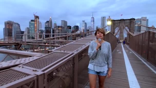 Νεαρή γυναίκα δημοσιογράφος Tv εκπέμπει περπατώντας στην γέφυρα του Μπρούκλιν — Αρχείο Βίντεο