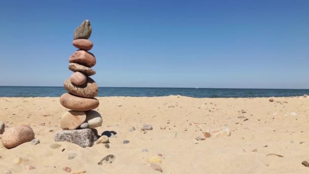 Guijarros en una pirámide en la orilla del mar — Vídeos de Stock