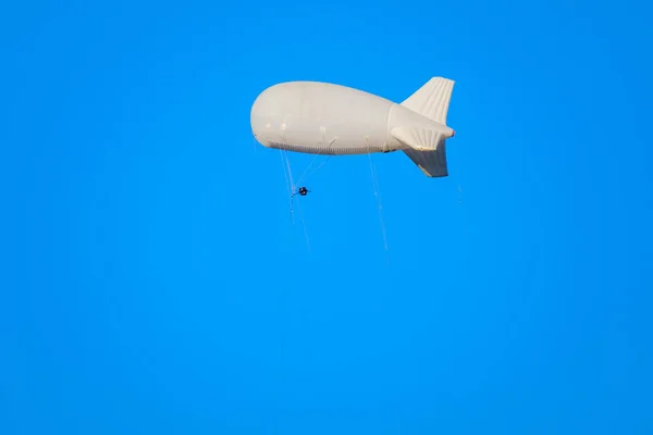 Dirigível voa no céu azul — Fotografia de Stock