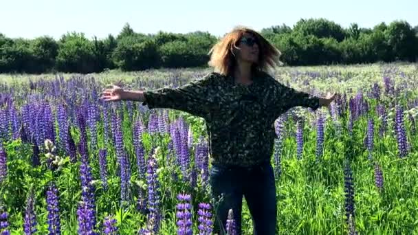 Young woman carelessly walking in a flowering meadow — Stock Video