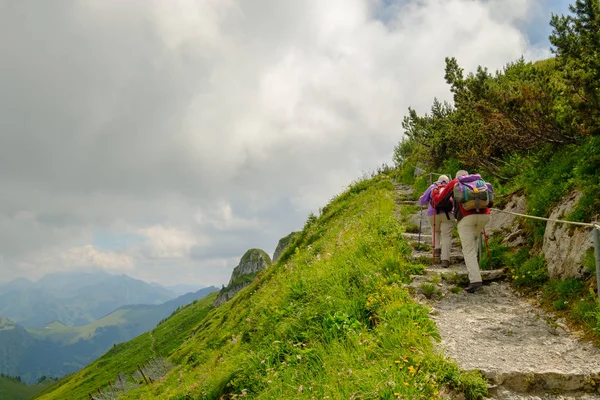 People hiking in Switzerland Alps at sunny day — Stock Photo, Image