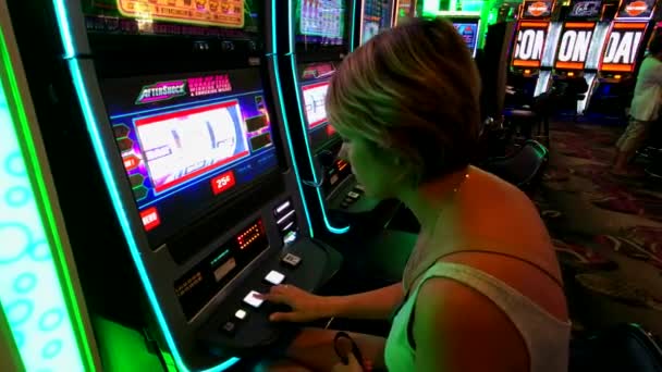 Люди играют в автоматы в казино MGM Стоковый Видеоролик