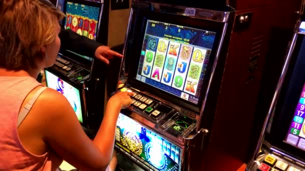 Woman playing slot machine in casino ⬇ Video by © toxawww Stock Footage  #236945146