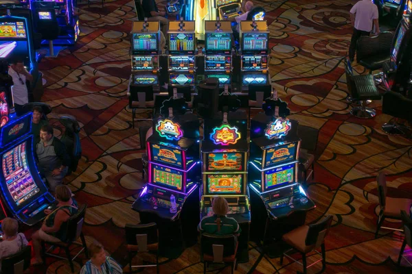 Люди играют в автоматы в казино MGM — стоковое фото