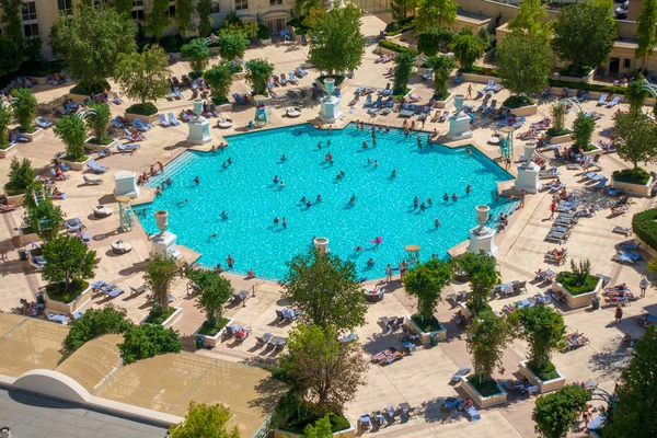 Gente relajándose en la piscina cerca del hotel — Foto de Stock