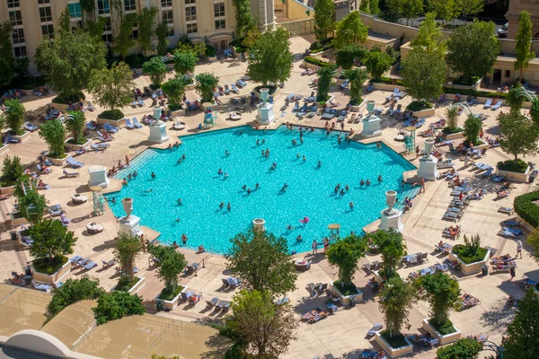 Gente relajándose en la piscina cerca del hotel — Foto de Stock