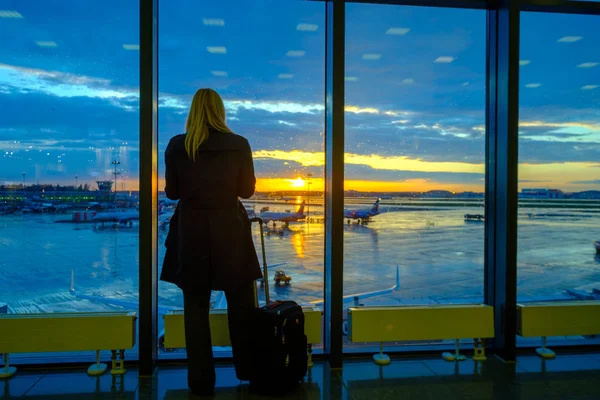 Frau steht am Flughafen am Fenster — Stockfoto