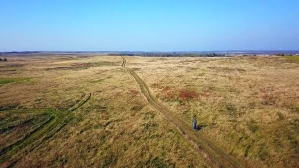 Vista aérea de um homem pedalando no caminho em um prado — Vídeo de Stock