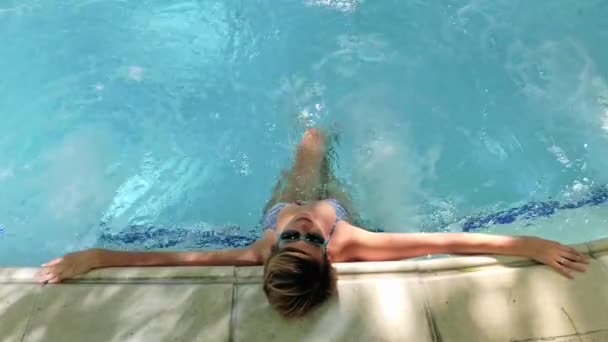 Mujer joven bronceándose en la piscina — Vídeo de stock