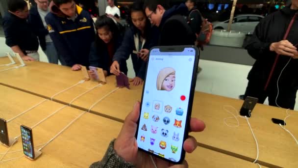 Wanita pengujian model baru Iphone XS Max di Apple store, mencoba untuk membuat animoji — Stok Video