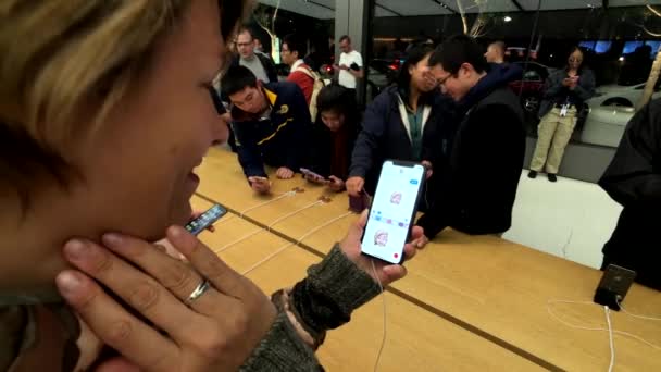 Mujer probando el nuevo modelo Iphone XS Max en la tienda Apple, tratando de crear animoji — Vídeo de stock