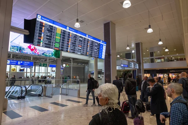 Os passageiros olham para as pranchas de chegada e partida no aeroporto — Fotografia de Stock