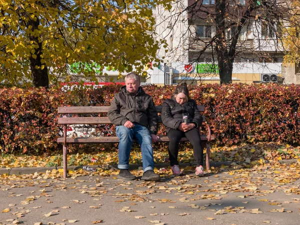 Pijany para bezdomnych usiąść na ławce w pobliżu stacji metra — Zdjęcie stockowe