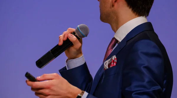 Homem fala, segurando um microfone — Fotografia de Stock