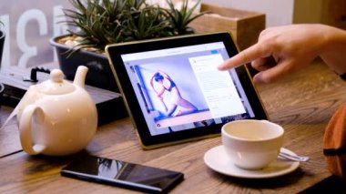 Adam Tablet PC kullanarak Yoga pratik insanların resimlere bakıyor