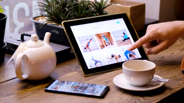 Adam Tablet PC kullanarak Yoga pratik insanların resimlere bakıyor — Stok video