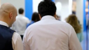 Salonda yürüyen bir iş konferansının ziyaretçileri