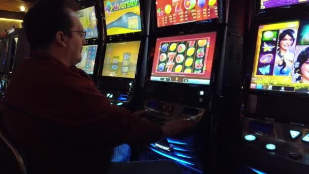 Hombre jugando máquina tragaperras en el casino — Vídeos de Stock