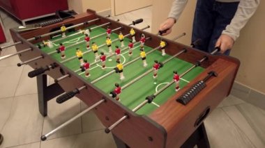 Masa futbolu oynayan iki adam.