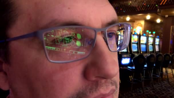 Чоловік грає в ігровий автомат в казино — стокове відео