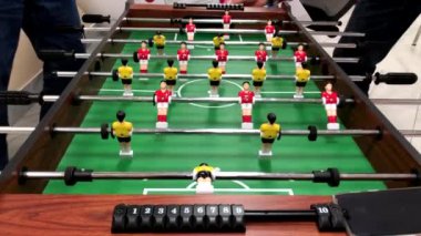 Masa futbolu oynayan iki adam.