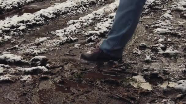 Caminante masculino camina a través del barro y charcos — Vídeo de stock